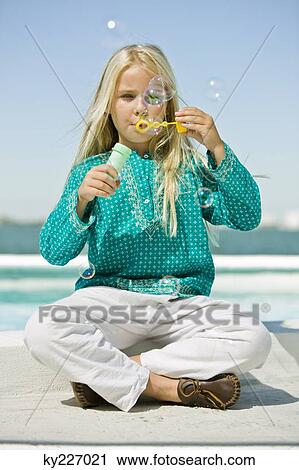 Girl blowing soap bubbles with a bubble wand View Large Photo Image Stock Image - Girl blowing soap bubbles with a bubble wand. Fotosearch
