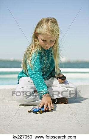 Girl playing with a remote controlled car View Large Photo Image Stock Image - Girl playing with a remote controlled car. Fotosearch