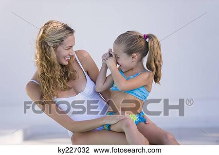Stock Image - Girl taking a picture of her mother. Fotosearch