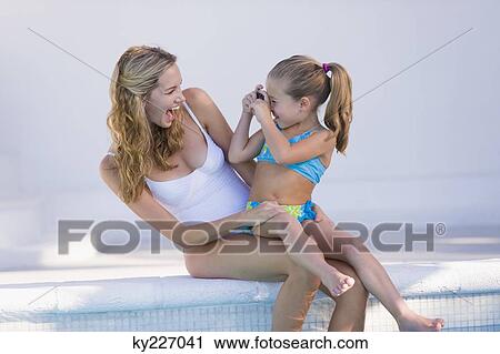 Stock Image - Girl taking a picture of her mother. Fotosearch