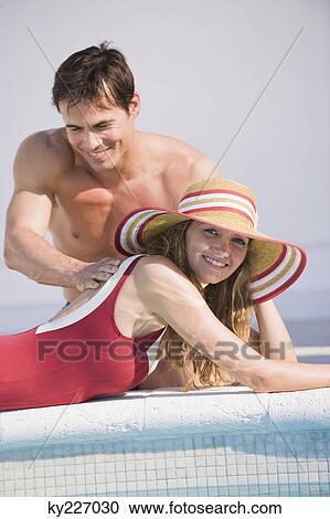 Man rubbing woman's back at the poolside View Large Photo Image Stock Image - Man rubbing woman's back at the poolside. Fotosearch