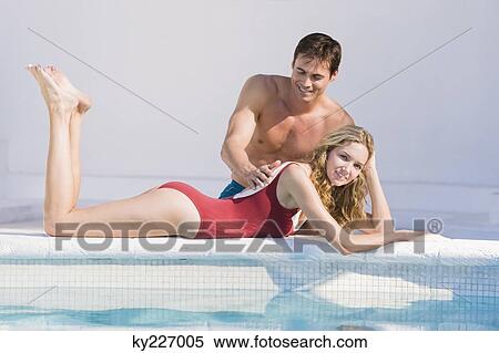 Man rubbing woman's back at the poolside View Large Photo Image Stock Photography - Man rubbing woman's back at the poolside. Fotosearch