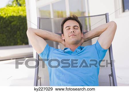 Man sleeping on a lounge chair View Large Photo Image Stock Photo - Man sleeping on a lounge chair. Fotosearch