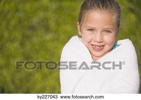 Stock Image - Portrait of a girl wrapped in a towel and smiling. Fotosearch