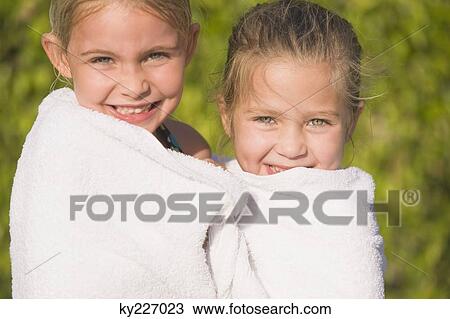 Portrait of two girls wrapped in a towel and smiling View Large Photo Image Stock Image - Portrait of two girls wrapped in a towel and smiling. Fotosearch