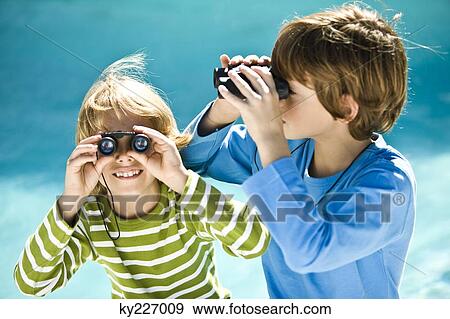 Two boys looking through binoculars View Large Photo Image Stock Photo - Two boys looking through binoculars. Fotosearch