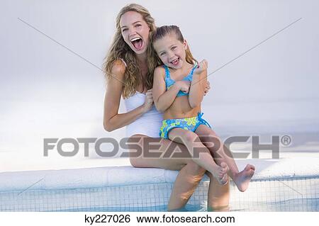 Woman with her daughter sitting at the poolside View Large Photo Image Stock Photograph - Woman with her daughter sitting at the poolside. Fotosearch