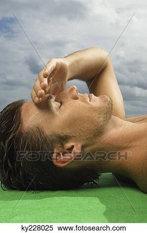 Close-up of a man sunbathing View Large Photo Image Stock Photography - Close-up of a man sunbathing. Fotosearch