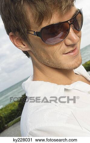 Close-up of a man wearing sunglasses View Large Photo Image Stock Image - Close-up of a man wearing sunglasses. Fotosearch