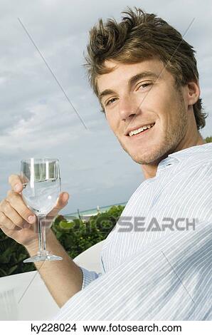 Portrait of a man holding a wine glass and smiling View Large Photo Image Picture - Portrait of a man holding a wine glass and smiling. Fotosearch