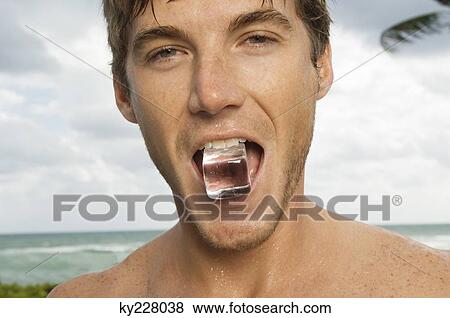 Portrait of a man holding ice cube in his mouth View Large Photo Image Stock Photo - Portrait of a man holding ice cube in his mouth. Fotosearch