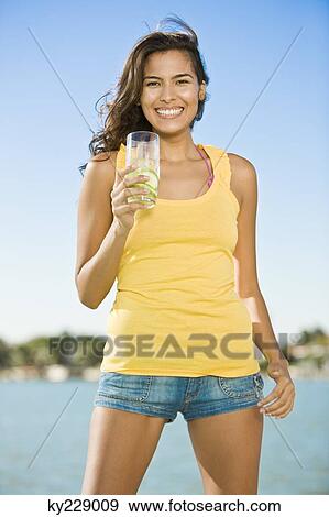 Portrait of a woman holding a glass of lemonade View Large Photo Image Stock Photo - Portrait of a woman holding a glass of lemonade. Fotosearch