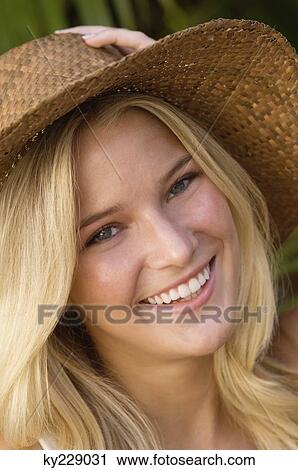 Stock Image - Portrait of a woman wearing sun hat and smiling. Fotosearch