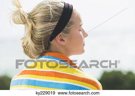 Rear view of a woman with a beach towel around shoulders View Large Photo Image Stock Photo - Rear view of a woman with a beach towel around shoulders. Fotosearch