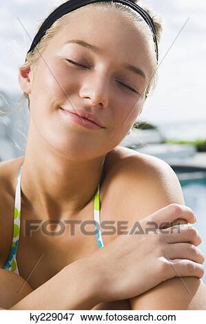 Woman day dreaming at the poolside View Large Photo Image Stock Photo - Woman day dreaming at the poolside. Fotosearch