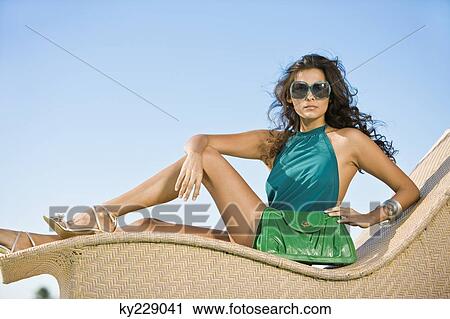 Stock Image - Woman posing on a chaise longue. Fotosearch