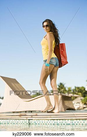 Woman walking with a bag at the poolside View Large Photo Image Stock Photograph - Woman walking with a bag at the poolside. Fotosearch