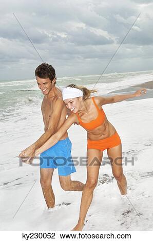 Couple enjoying on the beach View Large Photo Image Stock Image - Couple enjoying on the beach. Fotosearch