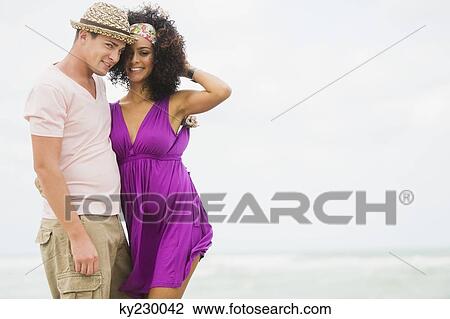 Couple standing on the beach and smiling View Large Photo Image Stock Image - Couple standing on the beach and smiling. Fotosearch