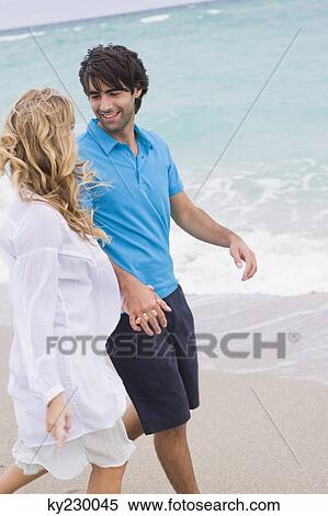 Couple walking on the beach View Large Photo Image Stock Photography - Couple walking on the beach. Fotosearch