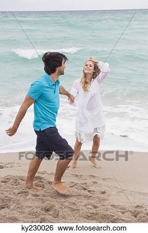 Couple walking with holding hands on the beach View Large Photo Image Stock Photograph - Couple walking with holding hands on the beach. Fotosearch