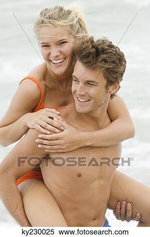 Man giving woman piggyback ride on the beach View Large Photo Image Stock Photography - Man giving woman piggyback ride on the beach. Fotosearch