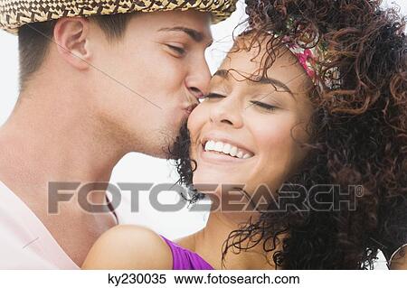 Man kissing a woman on cheek View Large Photo Image Stock Photography - Man kissing a woman on cheek. Fotosearch