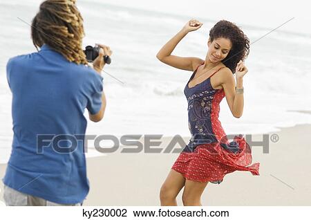 Man making a video of a dancing woman on the beach View Large Photo Image Stock Image - Man making a video of a dancing woman on the beach. Fotosearch
