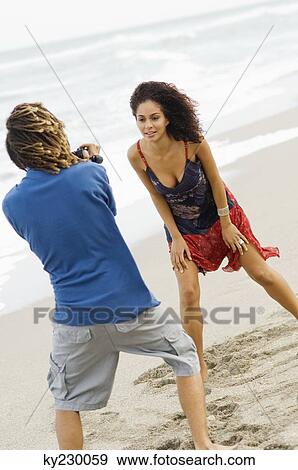 Man making a video of a woman on the beach View Large Photo Image Stock Photo - Man making a video of a woman on the beach. Fotosearch