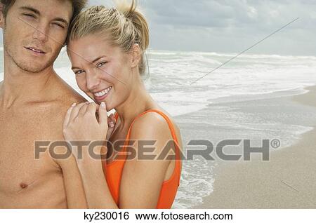 Stock Photograph - Portrait of a couple smiling on the beach. Fotosearch