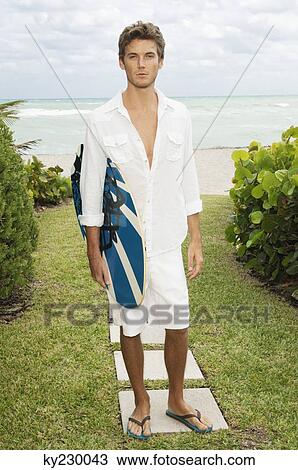 Portrait of a man holding a body board View Large Photo Image Stock Image - Portrait of a man holding a body board. Fotosearch