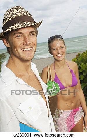 Stock Image - Portrait of a man smiling with his girlfriend. Fotosearch