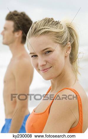 Portrait of a woman standing with a man on the beach View Large Photo Image Stock Photo - Portrait of a woman standing with a man on the beach. Fotosearch
