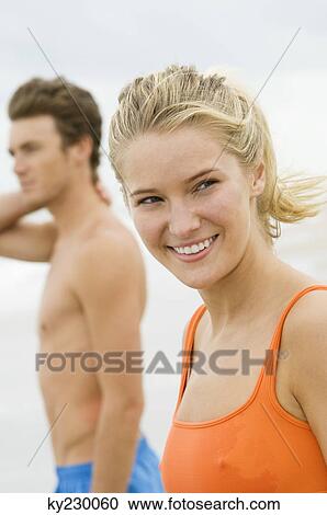 Woman standing with a man on the beach View Large Photo Image Stock Image - Woman standing with a man on the beach. Fotosearch
