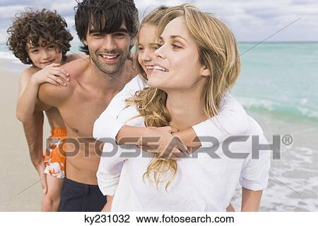 Couple giving piggyback ride to their children on the beach View Large Photo Image Stock Image - Couple giving piggyback ride to their children on the beach. Fotosearch