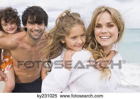 Couple giving piggyback ride to their children on the beach View Large Photo Image Stock Photography - Couple giving piggyback ride to their children on the beach. Fotosearch