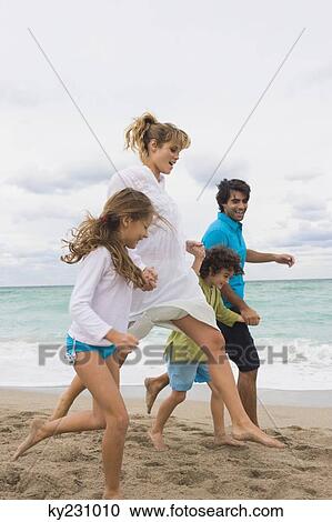 Family running on the beach View Large Photo Image Stock Image - Family running on the beach. Fotosearch