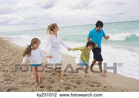 Family running on the beach View Large Photo Image Stock Image - Family running on the beach. Fotosearch