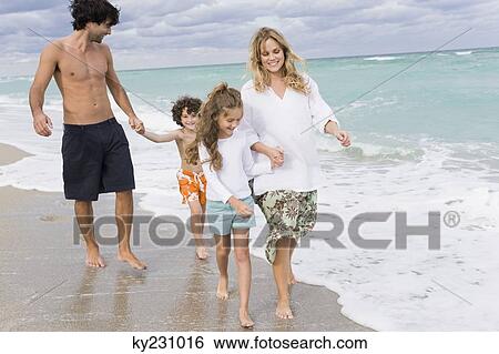 Family walking on the beach View Large Photo Image Stock Photograph - Family walking on the beach. Fotosearch