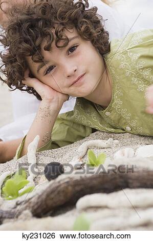 Portrait of a boy lying on the beach View Large Photo Image Stock Photograph - Portrait of a boy lying on the beach. Fotosearch