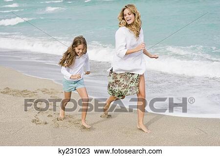 Woman running with her daughter on the beach View Large Photo Image Stock Image - Woman running with her daughter on the beach. Fotosearch