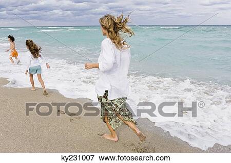 Woman with her children on the beach View Large Photo Image Stock Photo - Woman with her children on the beach. Fotosearch