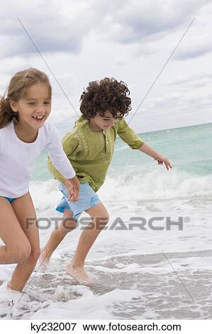 Boy and a girl running on the beach View Large Photo Image Stock Photo - Boy and a girl running on the beach. Fotosearch