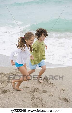 Boy and a girl running on the beach View Large Photo Image Stock Photograph - Boy and a girl running on the beach. Fotosearch