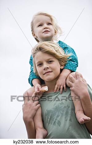 Boy carrying his sister on shoulders on the beach View Large Photo Image Stock Photo - Boy carrying his sister on shoulders on the beach. Fotosearch