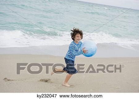 Boy playing on the beach View Large Photo Image Stock Photo - Boy playing on the beach. Fotosearch
