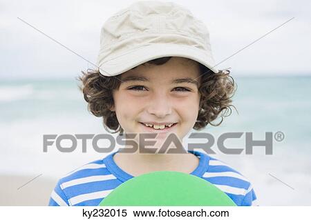 Boy playing with a plastic disc on the beach View Large Photo Image Stock Photography - Boy playing with a plastic disc on the beach. Fotosearch