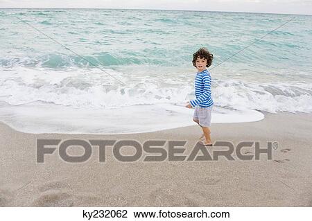 Boy standing on the beach View Large Photo Image Stock Image - Boy standing on the beach. Fotosearch