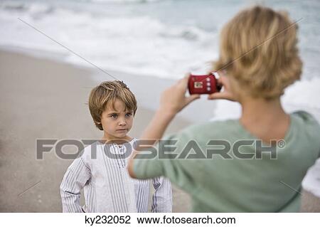Boy taking his brother's picture with a digital camera View Large Photo Image Stock Image - Boy taking his brother's picture with a digital camera. Fotosearch