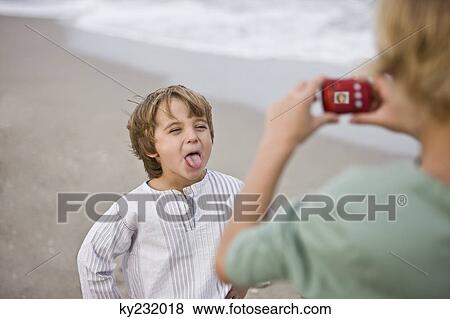 Boy taking his brother's picture with a digital camera View Large Photo Image Stock Photo - Boy taking his brother's picture with a digital camera. Fotosearch